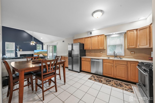 kitchen featuring ceiling fan, sink, stainless steel appliances, vaulted ceiling, and light tile patterned floors