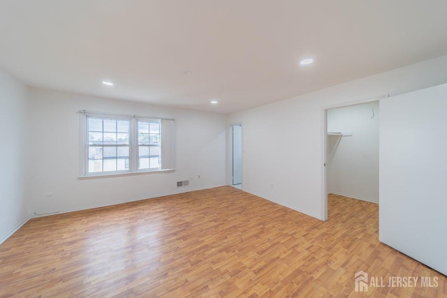 empty room with light wood-style flooring, recessed lighting, and baseboards