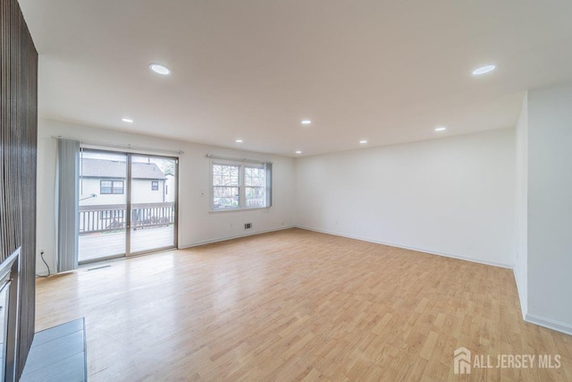 spare room featuring light wood-style flooring, recessed lighting, and baseboards