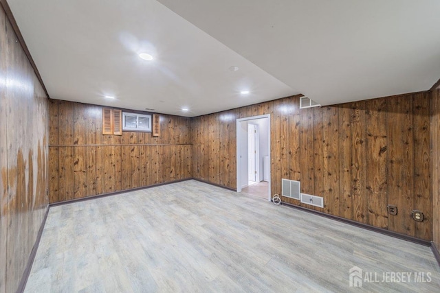 finished basement featuring wood walls, light wood-type flooring, and recessed lighting