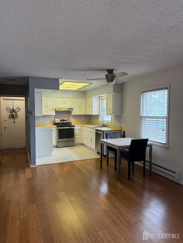 469-O New Haven Way, Monroe, NJ 08831 - kitchen featuring stainless steel appliances, baseboard heating, light countertops, light wood-style flooring, and a textured ceiling