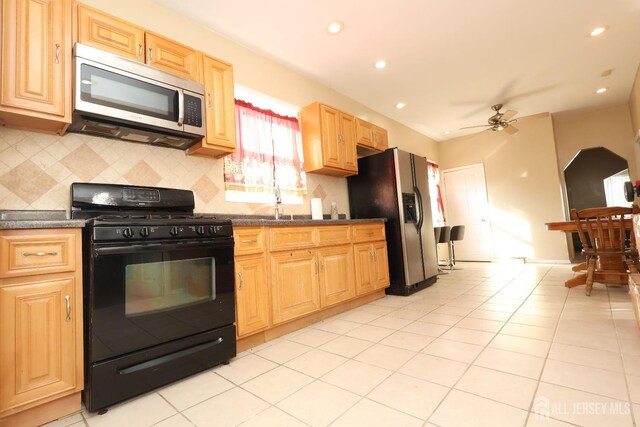 kitchen featuring light tile patterned floors, sink, ceiling fan, backsplash, and stainless steel appliances