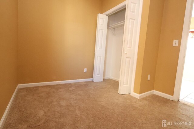 unfurnished bedroom with a closet and carpet flooring