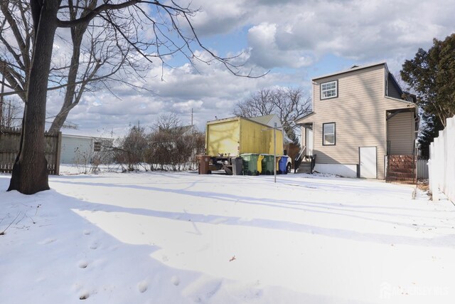 view of snow covered back of property