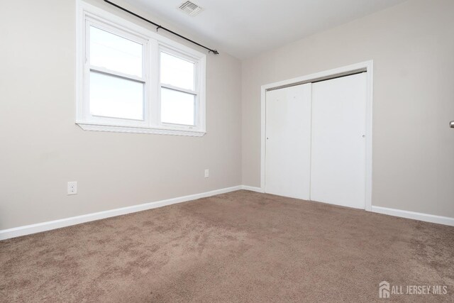 unfurnished bedroom featuring carpet and a closet