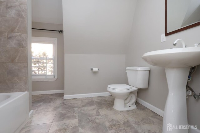 bathroom featuring lofted ceiling and toilet