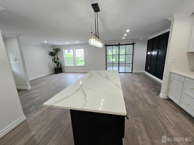 kitchen with a center island, open floor plan, crown molding, and wood finished floors
