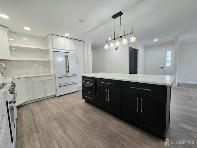 kitchen featuring dark cabinets, freestanding refrigerator, light wood-type flooring, and range