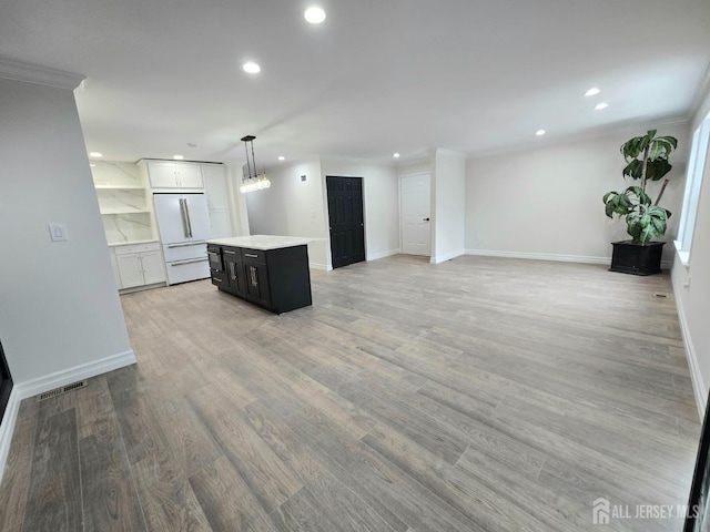 kitchen featuring freestanding refrigerator, recessed lighting, a center island, and light countertops