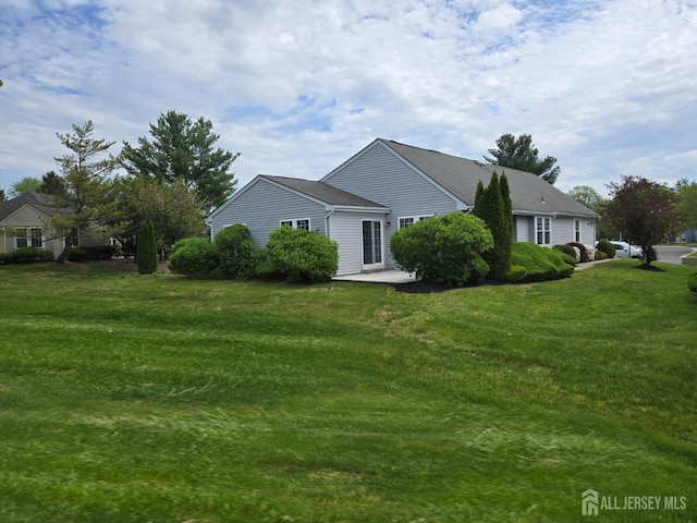 view of side of property featuring a patio area and a yard
