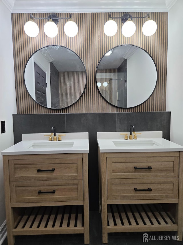 bathroom featuring a sink, two vanities, and ornamental molding