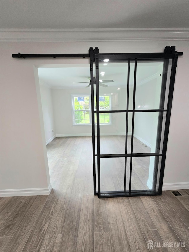 unfurnished room with ornamental molding and wood finished floors