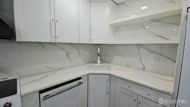 kitchen with tasteful backsplash, open shelves, dishwasher, a sink, and white cabinets