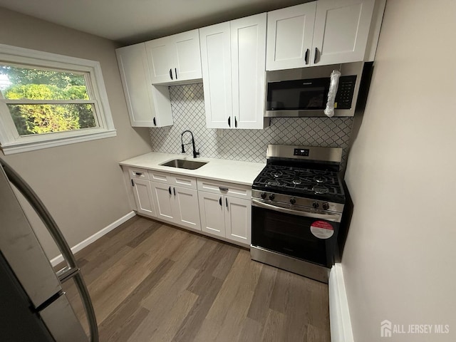 179 Buckelew Ave Unit A, Jamesburg, NJ 08831 - kitchen featuring stainless steel appliances, light countertops, dark wood-type flooring, decorative backsplash, and white cabinets