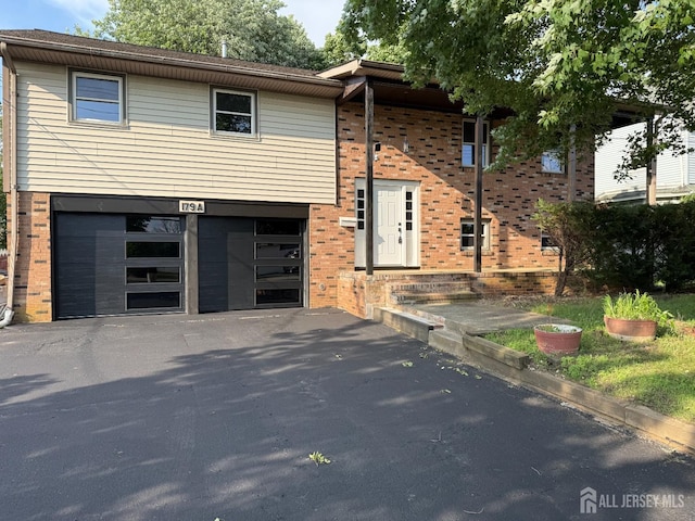 179 Buckelew Ave Unit A, Jamesburg, NJ 08831 - view of front facade featuring brick siding, a garage, and asphalt driveway