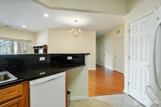 540 Cranbury Rd Unit 407, East Brunswick, NJ 08816 - kitchen featuring visible vents, brown cabinets, light tile patterned floors, a notable chandelier, and white appliances