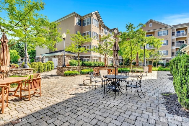surrounding community featuring a patio area and outdoor dining space