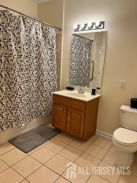 bathroom featuring vanity, tile patterned floors, shower / bath combo, and toilet