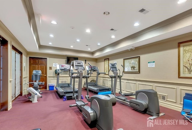 exercise room with visible vents, carpet flooring, and a tray ceiling