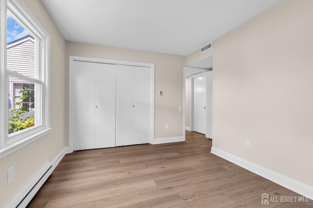 377-B Old Nassau Rd, Monroe, NJ 08831 - unfurnished bedroom with a baseboard radiator, light wood-style floors, and a closet