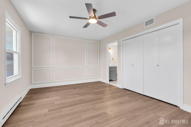 377-B Old Nassau Rd, Monroe, NJ 08831 - unfurnished bedroom with a baseboard heating unit, light wood-style flooring, a closet, a decorative wall, and connected bathroom