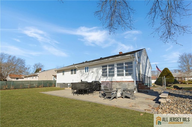 back of property with a yard and a patio area