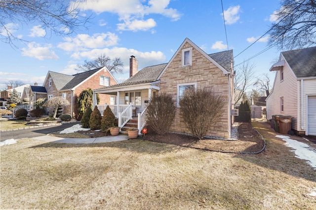 view of front of property featuring a gate, stone siding, covered porch, and a chimney
