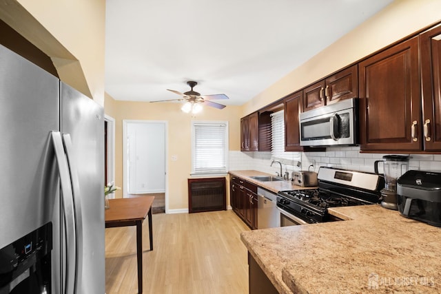 2903 Grasselli Ave, Linden, NJ 07036 - kitchen with appliances with stainless steel finishes, decorative backsplash, light countertops, light wood finished floors, and a sink