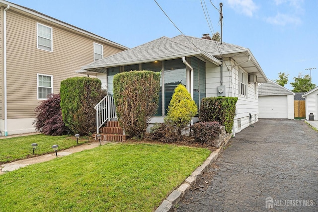2903 Grasselli Ave, Linden, NJ 07036 - bungalow-style house with a front yard, a garage, an outbuilding, and roof with shingles