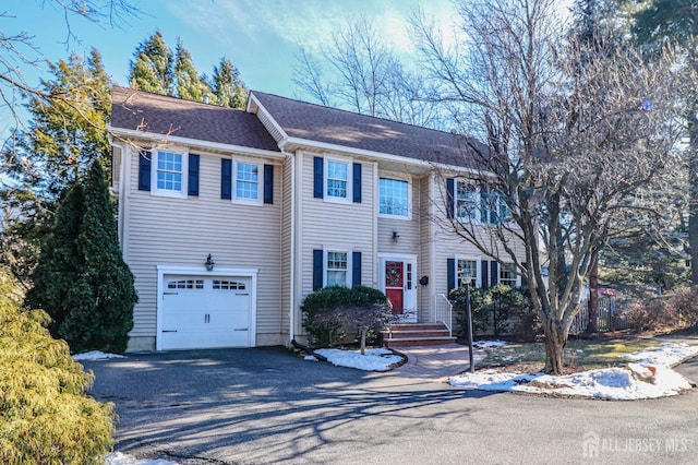 colonial inspired home with a garage and driveway