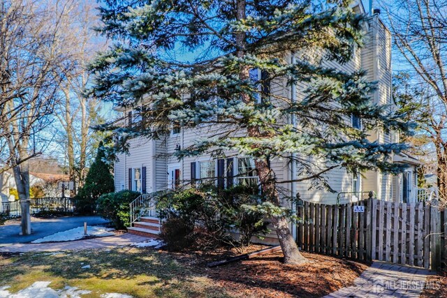 view of property exterior featuring fence and a chimney