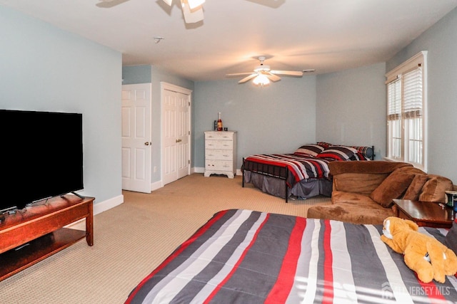 carpeted bedroom with ceiling fan and baseboards