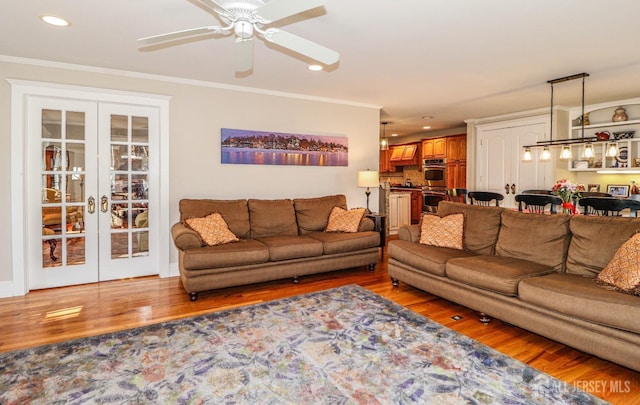 living area with light wood-type flooring, french doors, ornamental molding, and recessed lighting