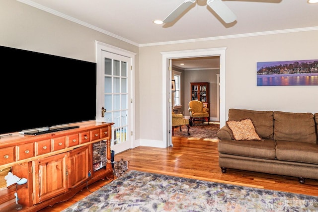 living room with crown molding, ceiling fan, baseboards, recessed lighting, and wood finished floors