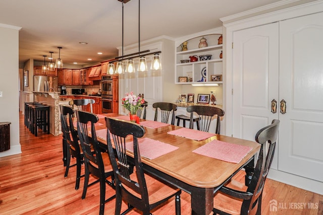 dining space with recessed lighting, crown molding, and light wood finished floors