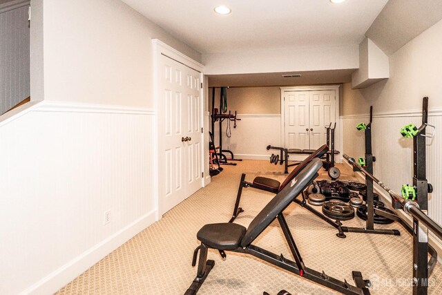 workout area with recessed lighting, carpet, and a wainscoted wall