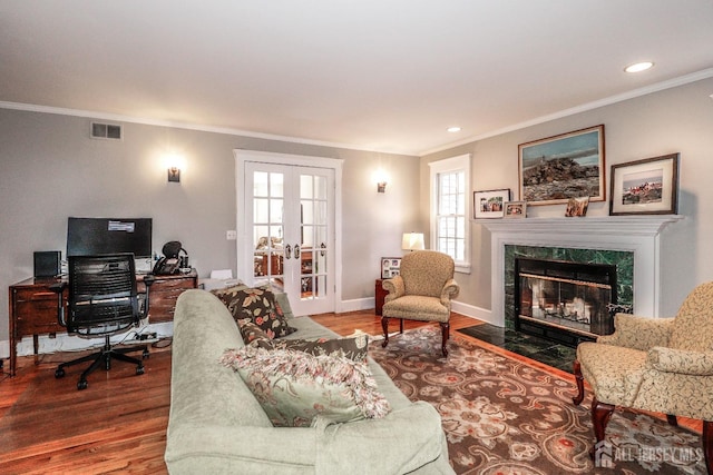 living area with visible vents, wood finished floors, french doors, a fireplace, and baseboards