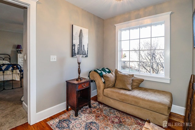 living area with baseboards and wood finished floors