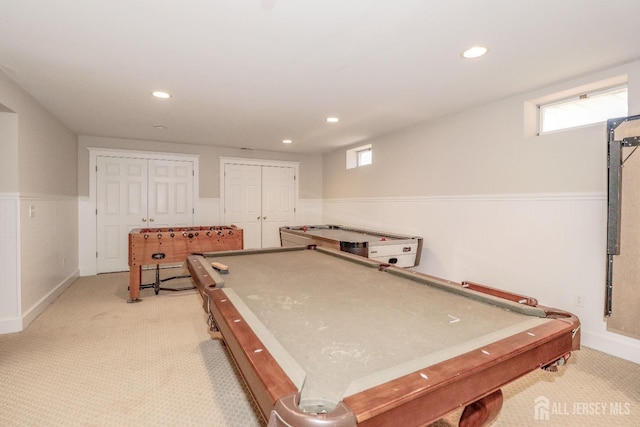 recreation room with a wainscoted wall, light colored carpet, a healthy amount of sunlight, and billiards