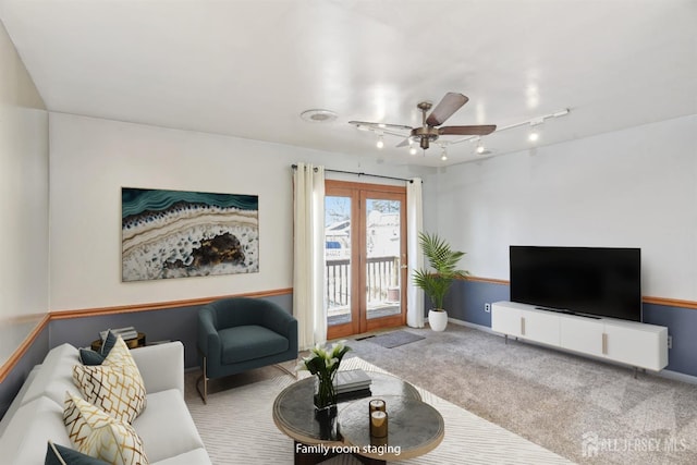 living room featuring rail lighting, ceiling fan, and carpet flooring