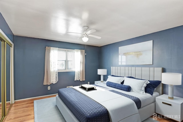 bedroom with light hardwood / wood-style flooring, a closet, and ceiling fan