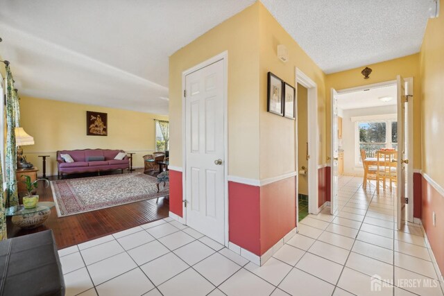 hallway with light tile patterned floors and a textured ceiling