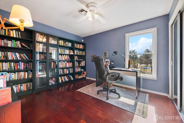 home office featuring ceiling fan, dark hardwood / wood-style flooring, and a textured ceiling