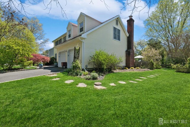 view of home's exterior featuring a garage and a lawn