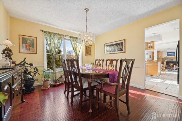 dining area featuring hardwood / wood-style floors, a notable chandelier, and a textured ceiling