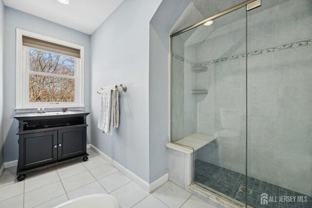 bathroom with a shower with shower door and tile patterned flooring