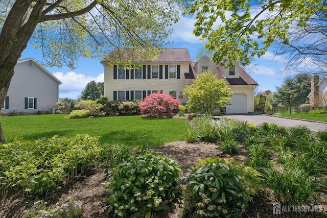 colonial house with a garage and a front lawn