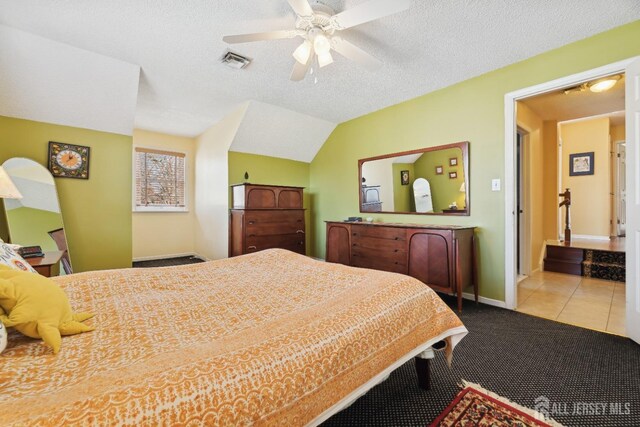 carpeted bedroom with ceiling fan, lofted ceiling, and a textured ceiling