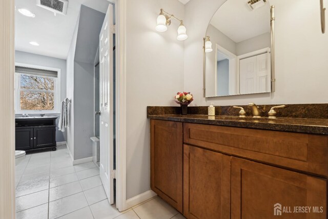 bathroom featuring tile patterned flooring, vanity, and toilet