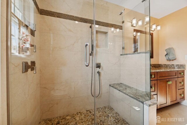 bathroom featuring vanity and a shower with door